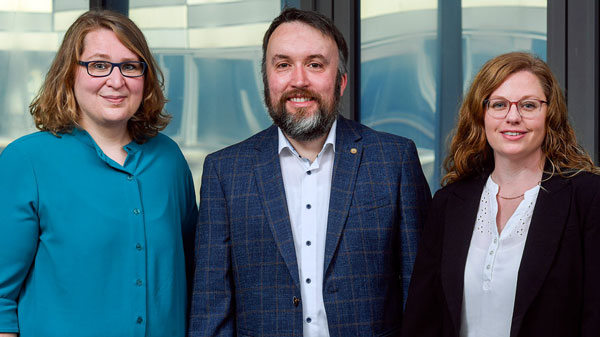 Porträtfoto der Studienberatung. Von links: Dorothee Konings trägt eine türkisfarbene Bluse, Dennie Oertel trägt ein dunkelblau kariertes Sakko und ein weißes Hemd und Anja Schöfer trägt einen schwarzen Blazer und eine weiße Bluse.