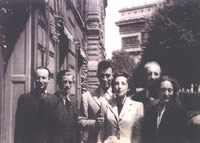 Photo noir et blanc d'un groupe de cinq personnes, avec l'Arc de triomphe en arrière-plan