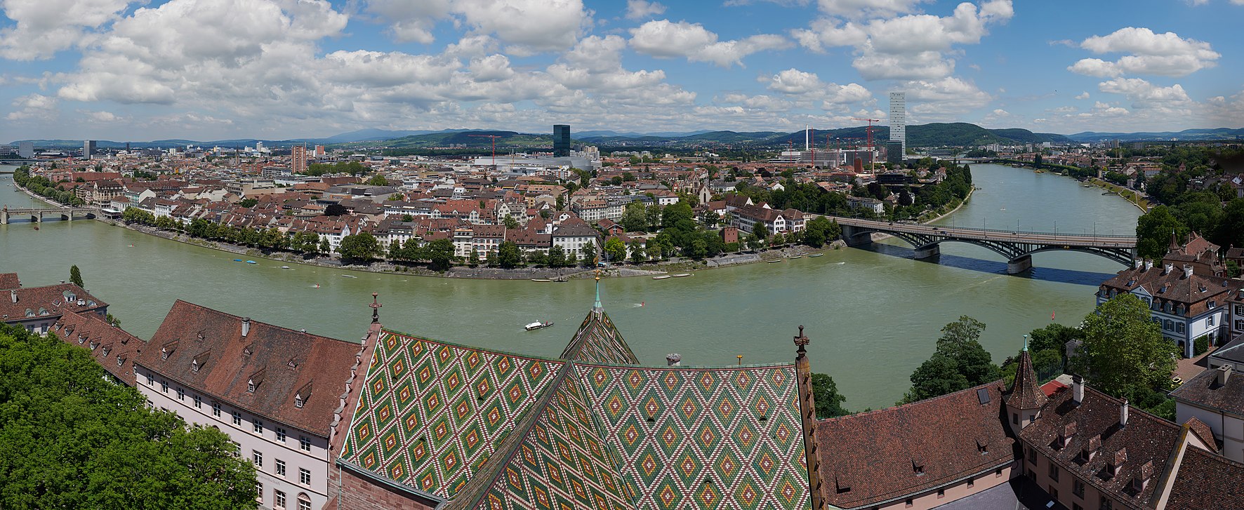 Blick vom Martinsturm des Basler Münsters auf Kleinbasel und das Rheinknie. Links am Rand ist die Mittlere Brücke zu erkennen, rechts sind Messeturm, Roche Tower und die Wettsteinbrücke zu erkennen.