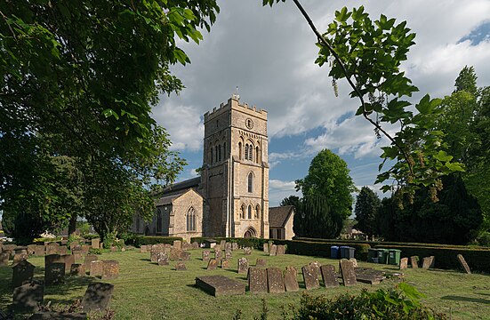 St. Peter's Church, Brackley, in 2023. View from a northwestern direction in afternoon light, with the curchyard in the foreground.