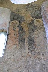 Painting of a man on a cross with two other men at his side praying towards him.