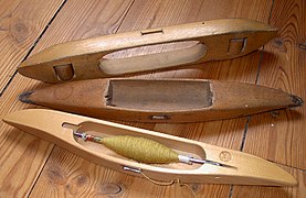 Top, an open boat shuttle (the other two are closed). Bottom, a Swedish-style asymmetrical shuttle with a paper quill. All are side-feed; the topmost one runs on rollers