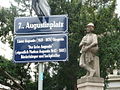 Straßenschild 7., Augustinplatz. Darunter Zusatztafel mit den biografischen Grunddaten des Namensgebers und der Namensgeberin, nach denen der Platz im Mai 2009 benannt wurde.