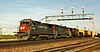 SP 8033, a Dash 8-39B, leads an EMD SD40T-2 and another GE locomotive westbound through Aurora, Illinois.