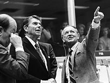 Photographie en noir et blanc de Kraft présentant au président Reagan le centre de contrôle de mission.