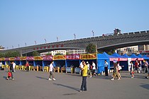 Stan promosi universitas dan perguruan tinggi Xi'an tahun 2009 di halaman stasiun, di belakang tampak Tembok Kota Xi'an