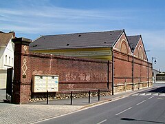 Deux bâtiments annexes en briques rouges.