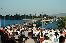 Hundreds of runners at the start line of a marathon at the O'ahu side of the Admiral Clarey bridge.