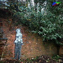 A mural by Hendog of two boys, one on the others shoulders, flying a rainbow-coloured kite