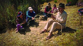 Voluntarios aprendiendo a construir una cuerda hecha a mano de hierba.