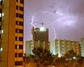 Una tormenta o tempestad es un fenómeno atmosférico caracterizado por la coexistencia próxima de dos o más masas de aire de diferentes temperaturas. El contraste térmico y otros factores atmosféricos propician intensas corrientes ascendentes y descendentes produciendo sus efectos, que son fuertes lluvias, viento intenso y los relámpagos. La presencia de relámpagos depende de la ionización y la intensidad de la tormenta. En la fotografía el Hotel Hesperia, en Hospitalet de Llobregat, Barcelona, Cataluña, España, al fondo una tormenta eléctrica. Por Yearofthedragon.