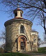 Un bâtiment religieux circulaire, de petite taille, dans un parc.