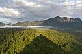 Ombre conique du mont Nam Xay au-dessus des arbres verts, tôt matin, avec des nuages pastel, vue sud-ouest du sommet, à Vang Vieng.