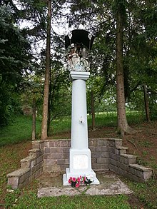 A white pole with trees and stairs near it