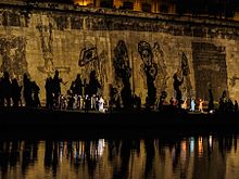 Bemalte Mauer mit riesigen Schatten am Ufer des Tiber, die die Siege und die Niederlagen der römischen Geschichte symbolisieren