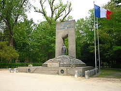 Immense monument des diables bleus avec au centre la statue d'un chasseur alpin. Un grand drapeau français flotte à droite du monument.