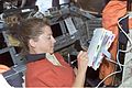 Pamela Melroy looks over a checklist on the flight deck of Atlantis