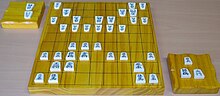 Shogi - Japanese chess. Board, pieces and komadai in a typical game situation.