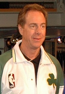 Portrait photograph of white man wearing white and green top