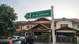 Biển hiệu đường phố chữ Jawi Shah Alam, Malaysia mang chữ viết Roman.