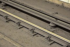 Third rail (top) at Bloor-Yonge station (Line 1) on the Toronto subway. Energized at 600 volts DC, the third rail provides electrical power to the power-train, and ancillaries of the subway cars.