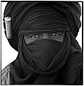 Ein Tuareg aus Timia mit schwarzem Tagelmust, eingewickelt in die Silberschmuckpatrone trägt er eingerollte Verse aus dem Koran (2003)