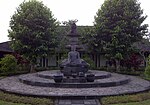 Patung Buddha yang tidak sempurna di dalam museum. Di belakangnya diletakkan chhtra atau parasol tiga tingkat yang seharusnya berada di puncak stupa utama Borobudur, tetapi diturunkan dengan pertimbangan sering terkena sambaran petir.