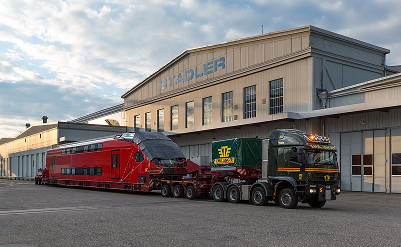 File:Aeroexpress KISS at Altenrhein, Stadler works, loaded onto truck.jpg