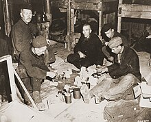 Five men sitting in a circle on the floor of a barracks