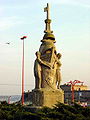 Monumento ó emigrante, co castelo de San Antón no fondo