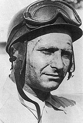 Black and white photograph of an helmeted Juan Manuel Fangio