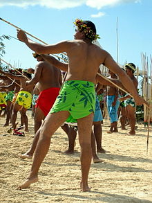 Des hommes sur une plage, tenant des javelots et s'apprêtant à les lancer