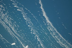 Fish Island (left) and Fisherman Shoal (to the right) on February 22, 2014 with ice stringers; north is oriented to the left. During February 2014, Lake Michigan's waters were lower at 175.95 meters above sea level.[4] Photo taken during Expedition 38 of the International Space Station.[5]