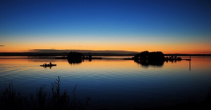 Sunset on the lake just north of The Entrance, NSW with a couple of paddlers enjoying the evening calm.