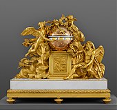 Ceasul de șemineu „Triumful Iubirii asupra Timpului”; circa 1780-1790; bronz doré, marmură și email; per ansamblu: 94 x 104,1 x 31,8 cm; Muzeul Metropolitan de Artă