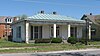 Front and side of a white house with pillars on the facade