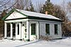 Photo, with snow, of a small Greek Revival-style building, from 2010