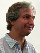 Portrait de David Shore souriant en conférence de presse.