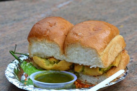 Vada pav disajikan dengan cabai hijau yang digoreng dan chutney bawang putih