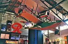 The Boeing B-1 on display in the museum's Grand Atrium, with the Rainier Brewing Company logo sign behind.