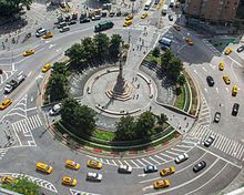 Photographie aérienne d'un rond-point partiellement piéton avec une statue en son centre.