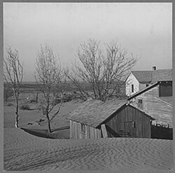 Dust starts to bury a barn in Kansas