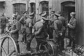 Stroop Report, showing Blösche at left. Original caption "Die Räumung eines Betriebes wird besprochen" {The clearance of a factory is being discussed-Herman Brauer helm repair shop at Nalewki 28–38. 24 April 1943}.