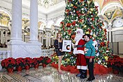 Carla Hayden and Santa Claus present pop superstar Mariah Carey with a framed certificate honoring her induction into the 2023 Library of Congress National Recording Registry for “All I Want for Christmas Is You” (14 December 2023)