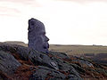 Arne Garborg, ved skrivestuen hans i Knudaheio. Steinansiktet «All denne fagre utsyn», er laget til Garborgjubileet i 2001. Foto: Onar Vikingstad