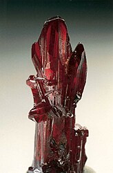 Proustite (long prismatic crystal) – Chañarcillo, Copiapo Province, Chile. Specimen height is 4 cm.