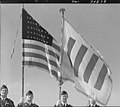 1943 photo of U.S. soldiers flying the U.S. flag and the Honor flag