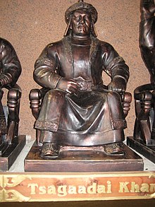 Statue of a robed man sitting; a plaque displays his title, Tsagaadai Khan.