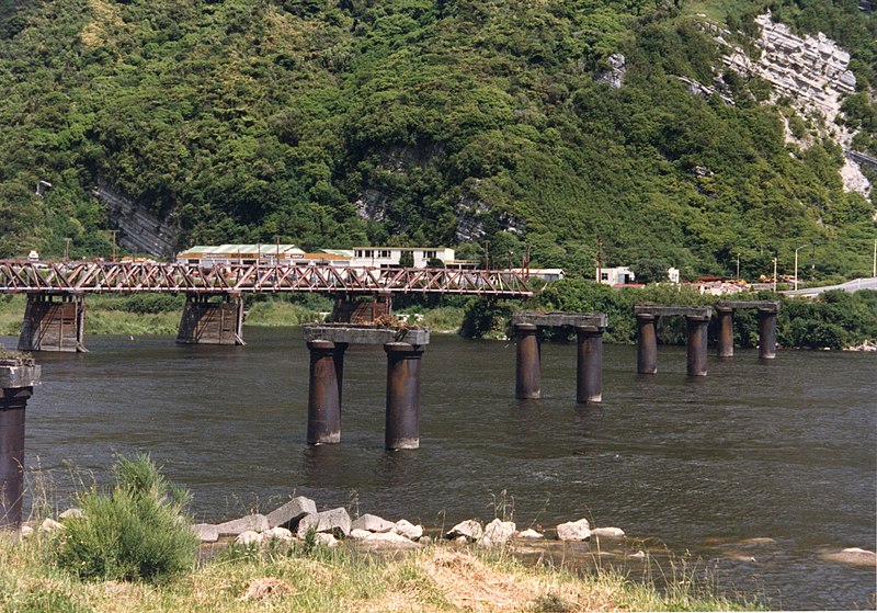 File:Old Cobden Bridge pillars in Grey River and Rail Bridge, Greymouth, 1987. CC129.jpg