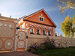 A decorated wooden house and a fence in front